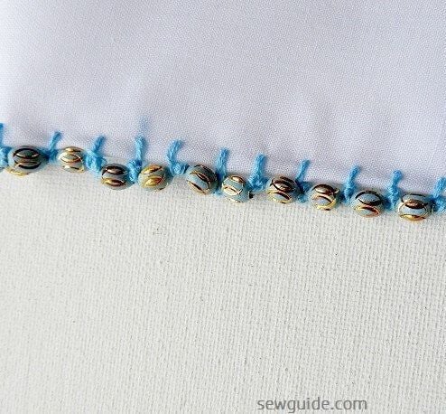 装饰边缘针迹，沿着围巾或领口的边缘有珠子